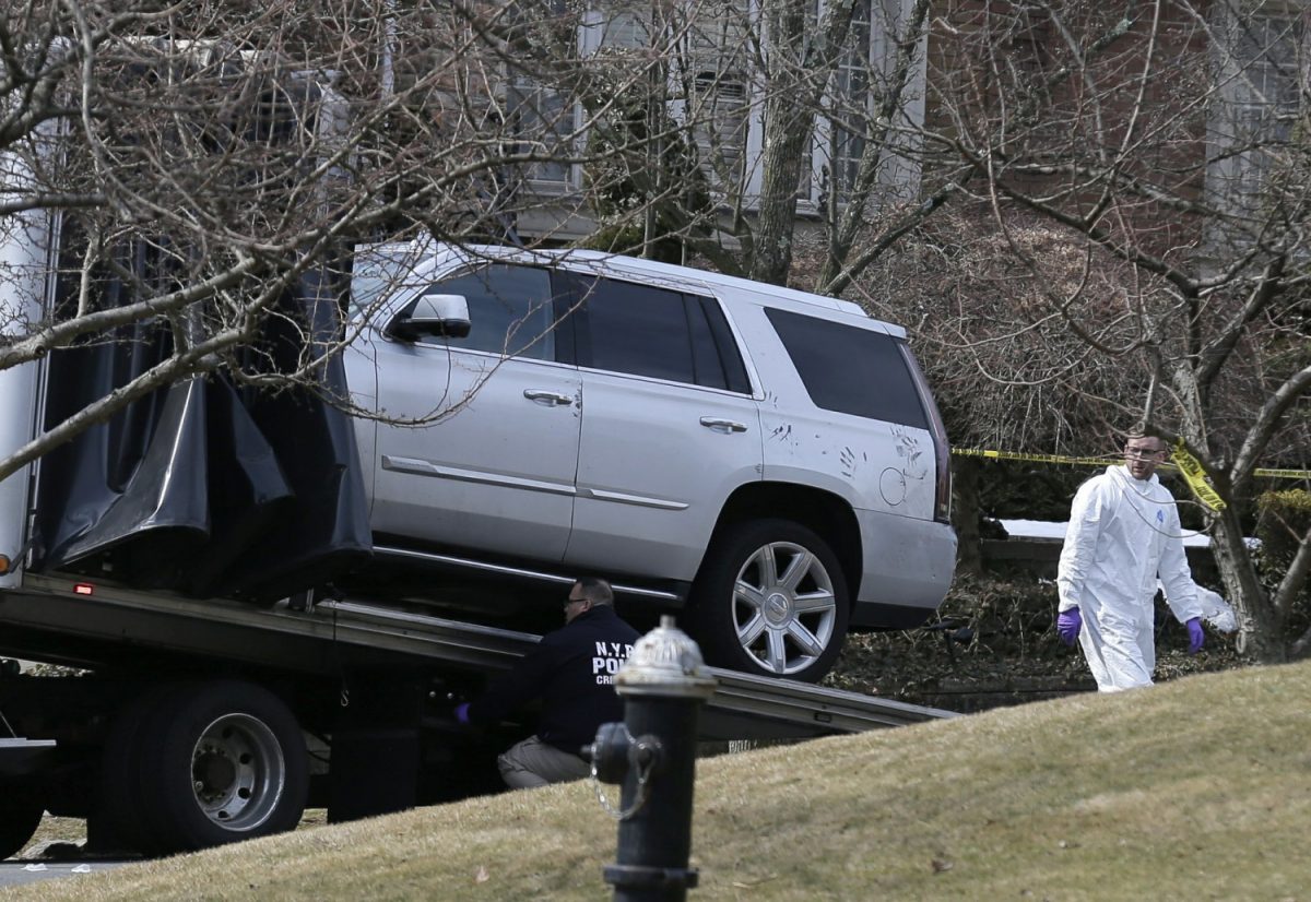 Crime scene investigators load a car that appears to have been checked for fingerprints onto a flatbed truck in the Staten Island borough of New York on March 14, 2019. (Seth Wenig/AP Photo)