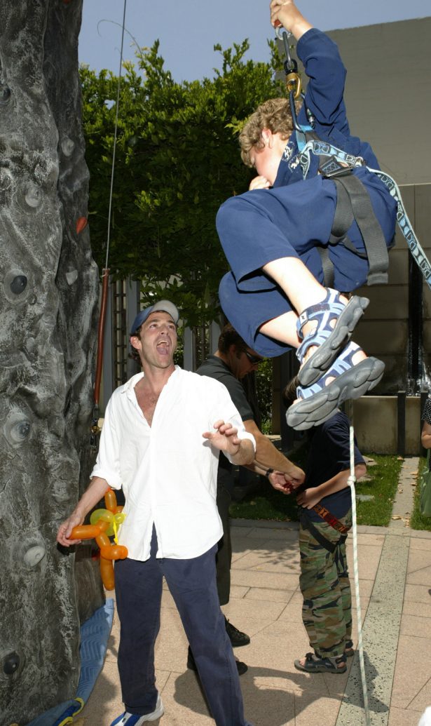 Actor Luke Perry reacts to son Jack's climbing ability at an afterparty for the premiere of "Garfield-The Movie" at the Twentieth Century Fox studio lot in Los Angeles, Calif., on June 6, 2004. (Photo by Vince Bucci/Getty Images)