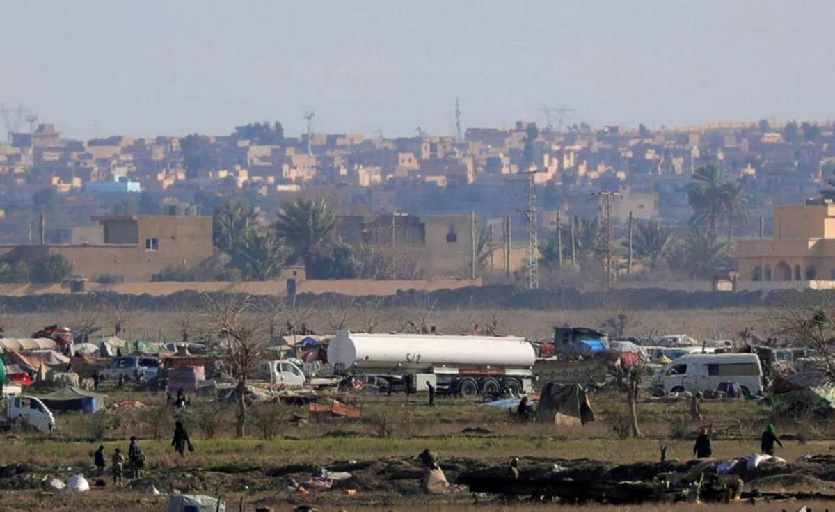 Islamic state members walk in the last besieged neighborhood in the village of Baghouz, Deir Al Zor province, Syria, on Feb. 18, 2019. (Rodi Said/Reuters)