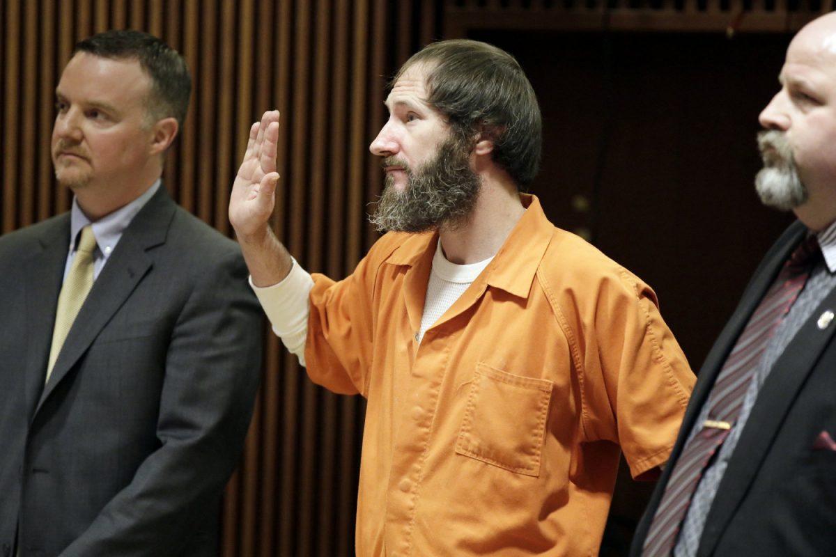 Attorneys Stephen P. Hunter, left, and John Keesler, right, stand with Johnny Bobbitt as he is sworn in by Superior Court Judge Christopher Garrenger at the Burlington County Courthouse in Mount Holly, N.J., on March 8, 2019. (Elizabeth Robertson/The Philadelphia Inquirer via AP)