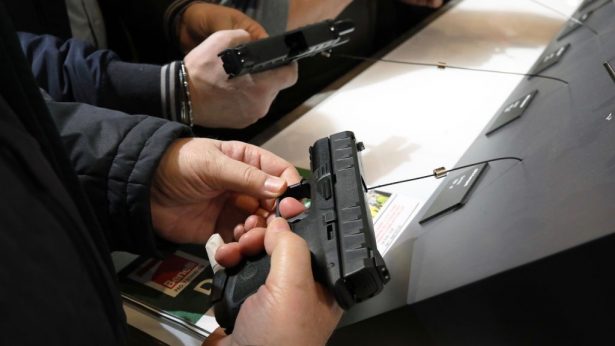 Gun enthusiasts are seen holding short guns at the Beretta Gun factory stand at the HIT Trade Show in Vicenza, Italy on Feb. 9, 2019. (Marco Di Lauro/Getty Images)