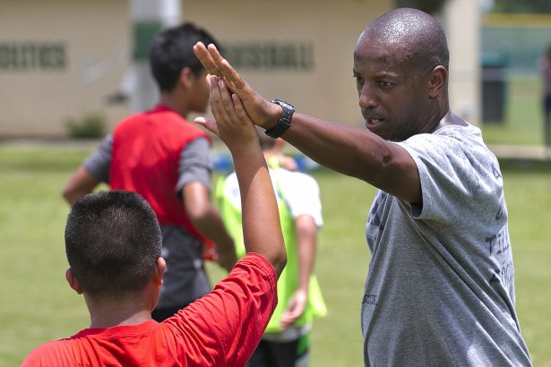 Yale's women's Head Soccer Coach Rudy Meredith gives a high five to a player after making a great play in a scrimmage, in Frankfort, Ky., in September 2016. (Doug Engle/Star-Banner via AP)