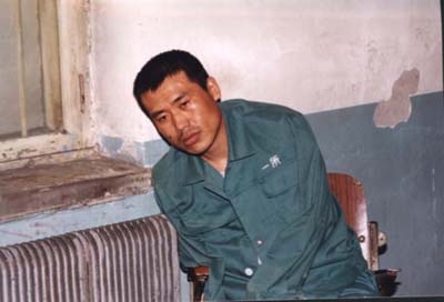 This is the last known photo of Liu Chengjun. Due to torture, he could no longer sit up by himself and had to lean against the wall, and his left arm was broken. (Friends of Falun Gong)