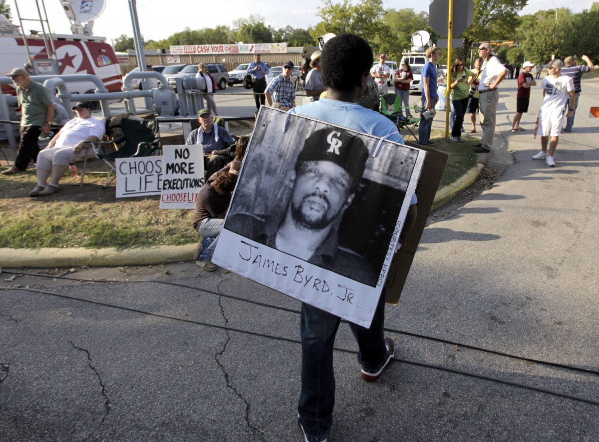 A man wears a photograph of James Byrd Jr. outside the Texas Department of Criminal Justice Huntsville Unit before the execution of Lawrence Russell Brewer in Huntsville, Texas, on Sept. 21, 2011. (David J. Phillip/AP Photo)