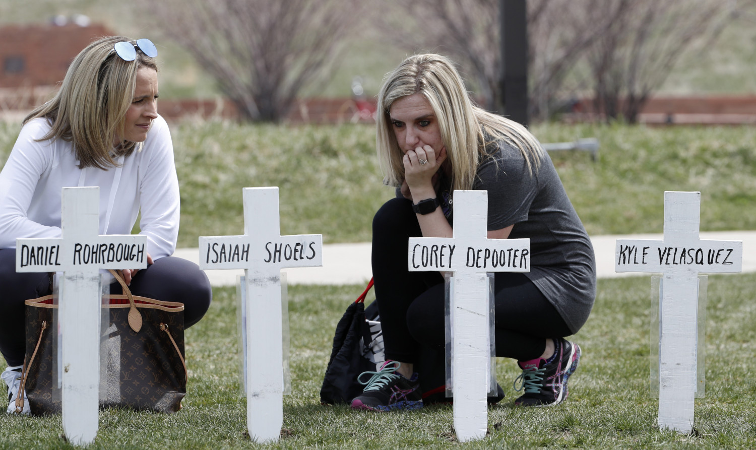 Cassandra Sandusky (R) a graduate of Columbine High School, pauses at a row of crosses bearing the names of the victims of the attack at the school on April 20, 2019. (David Zalubowski/AP Photo)