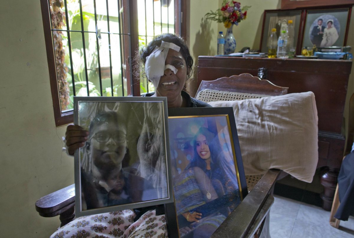 Anusha Kumari holds portraits of her daughter Sajini Venura Dulakshi and son Vimukthi Tharidu Appuhami, both victims of Easter Sunday's bomb blast in Negombo, Sri Lanka, on April 24, 2019. (Gemunu Amarasinghe/Photo via AP)