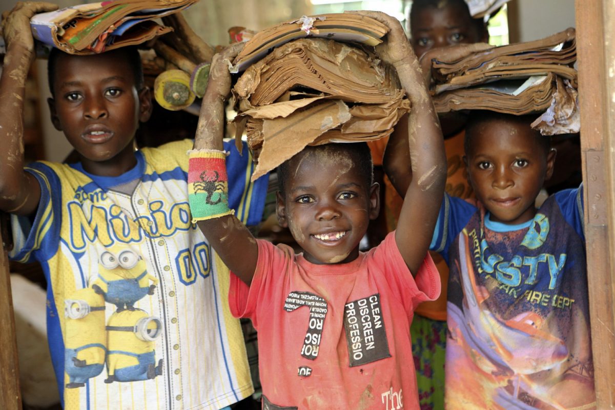 Children carry books damaged by the cyclone at a camp for displaced survivors of cyclone Idai in Dombe, Mozambique, on April 4, 2019. (Tsvangirayi Mukwazhi/Photo via AP)