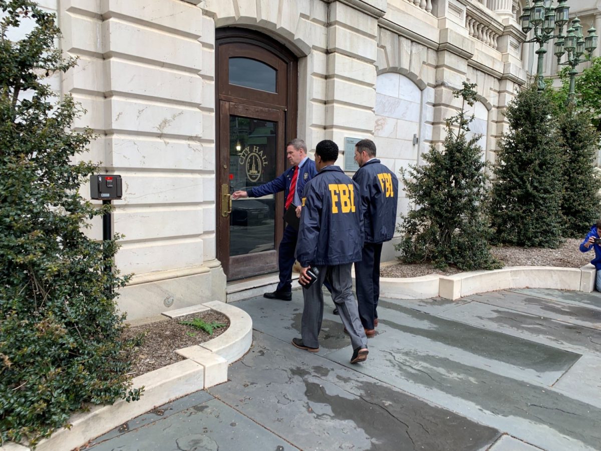 Federal Bureau of Investigation and Internal Revenue Service agents enter City Hall in Baltimore, MD., on April 25, 2019. (Ian Duncan/The Baltimore Sun via AP)