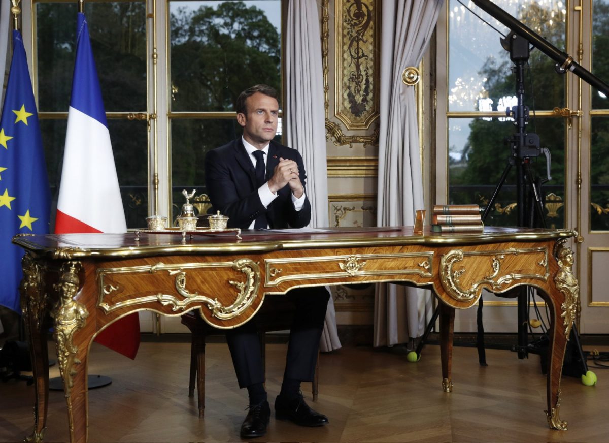 French President Emmanuel Macron sits at his desk after addressing the French nation following a massive fire at Notre Dame Cathedral, at Elysee Palace in Paris, on April 16 2019. (Yoan Valat, Pool via AP)