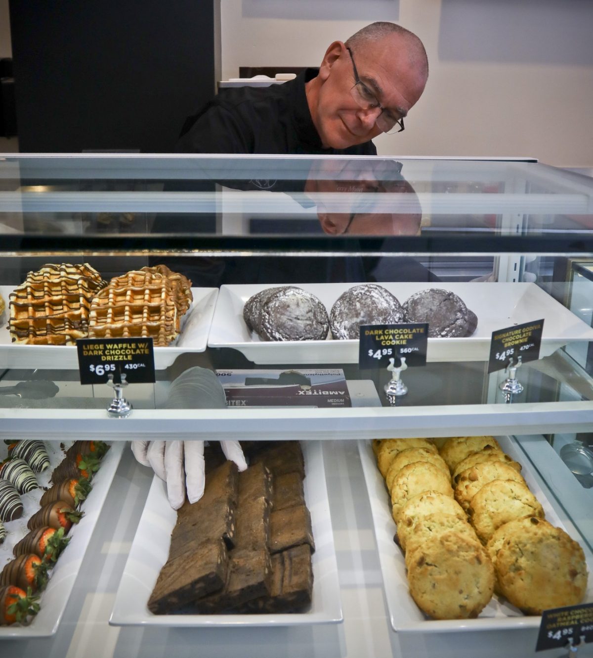 Executive chef Thierry Muret arranges a pastry display at Godiva's new cafe in N.Y., on April 16, 2019. (AP Photo/Bebeto Matthews)