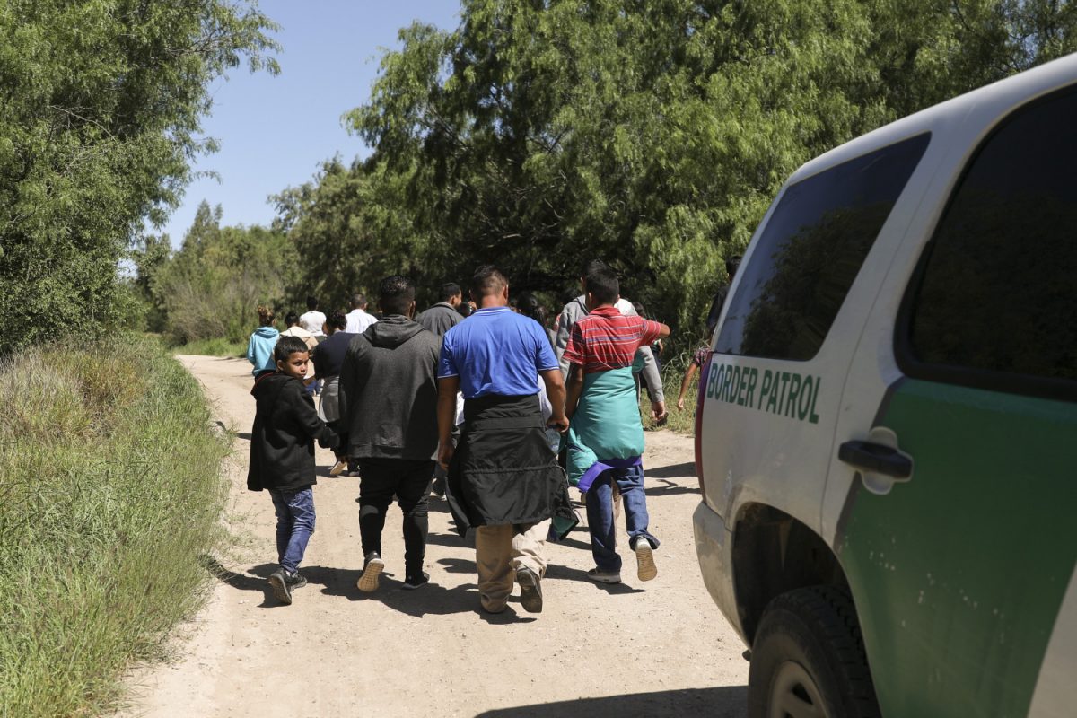 A group of illegal aliens walk up the road after crossing the Rio Grande from Mexico. Further up the road, they will be processed by Border Patrol and then board a bus bound for the Border Patrol processing facility in McAllen, Texas, on April 18, 2019. (Charlotte Cuthbertson/The Epoch Times)