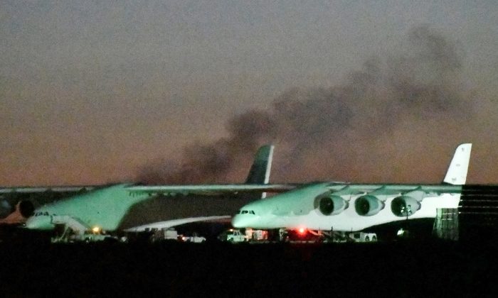 Heavy black smoke rises from one of the six engines starting, before the first test flight of the world's largest airplane, built by the late Paul Allen's company Stratolaunch Systems, in Mojave, Calif. on April 13, 2019. (REUTERS/Gene Blevins)