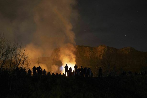 People watch the scene of a gorse fire below Salisbury Crags in Holyrood Park, Edinburgh, Scotland, on Feb. 26, 2019. ( Jane Barlow/PA Wire via AP)