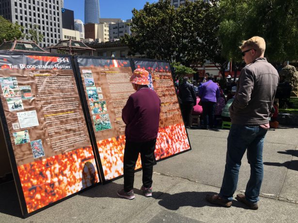 People stopped to learn more about the protest at the exhibit in Portsmouth Square in San Francisco on May 27, 2019. (Ilene Eng/NTD)