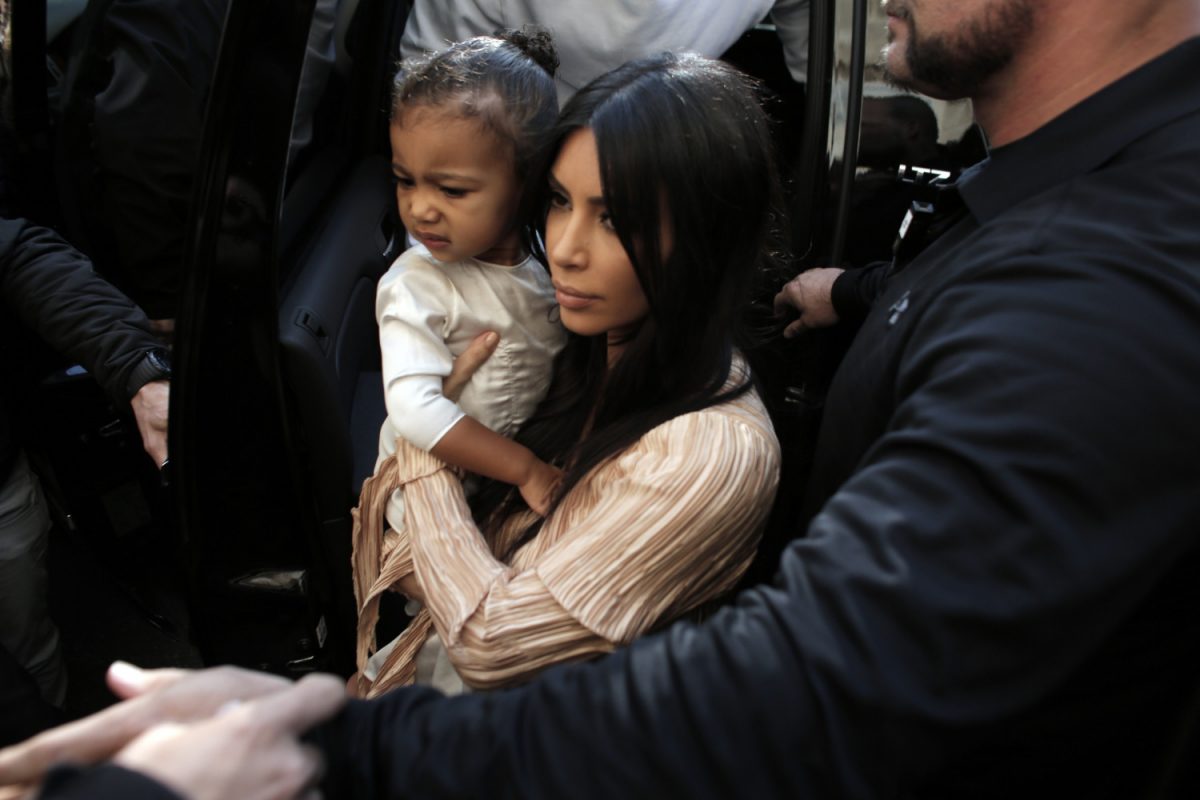 Reality TV star Kim Kardashian carries her daughter North West as she and her husband rapper Kanye West (back) exit a car upon their arrival at the Armenian St. James Cathedral in Jerusalem's Old City for a reported baptism ceremony of their child, on April 13, 2015. (Ahmad Gharabli/AFP/Getty Images)
