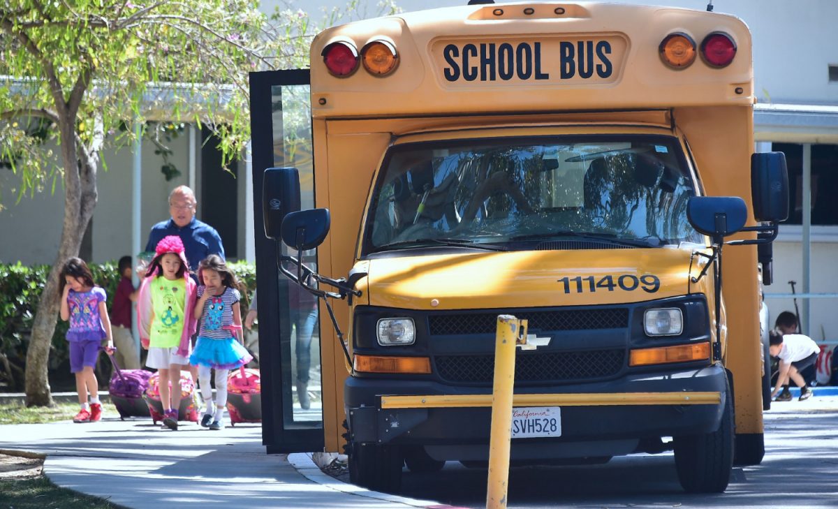 Children walk past a school bus. (Frederic J. Brown/AFP/Getty Images)