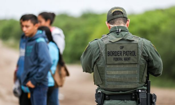 A Border Patrol agent apprehends illegal immigrants who have just crossed the Rio Grande from Mexico into Penitas, Tex., on March 21, 2019. (Charlotte Cuthbertson/The Epoch Times)