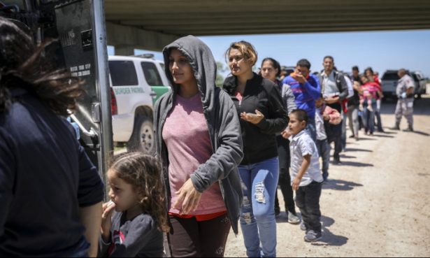 A large group of illegal aliens boards a bus bound for the Border Patrol processing facility after being apprehended by Border Patrol near McAllen, Texas, on April 18, 2019. (Charlotte Cuthbertson/The Epoch Times)