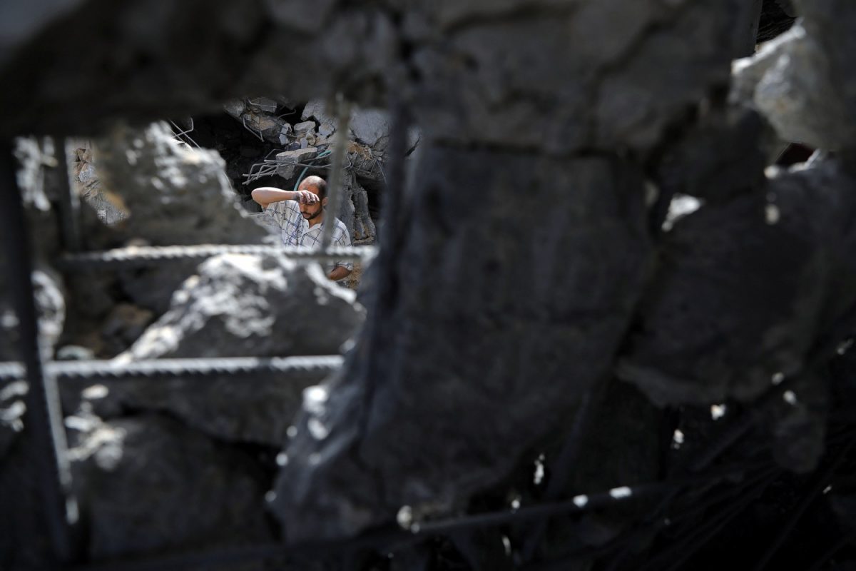 A Palestinian man is seen through the rubble of an apartment block that was hit by an Israeli air strike, in the northern Gaza Strip on May 5, 2019. (Mohammed Salem/Reuters)