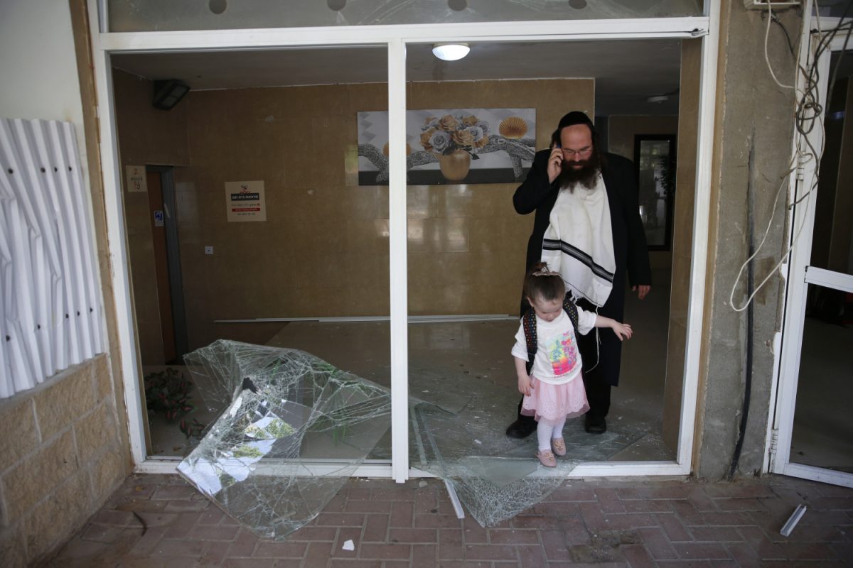 A man and girl survey damage from a rocket launched from the Gaza Strip in Ashdod, Israel, on May 6, 2019. (AP Photo/Ariel Schalit)