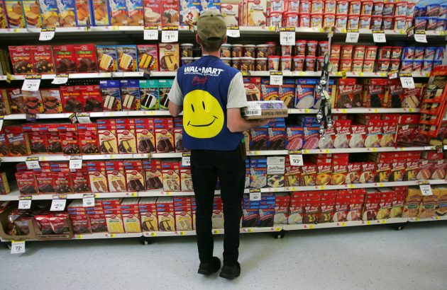 An employee restocks a shelf in the grocery section of a Wal-Mart Supercenter. Grocery store workers are now considered emergency personnel in Minnesota and Vermont amidst the CCP virus wave that sweeps the world (Chris Hondros/Getty Images)