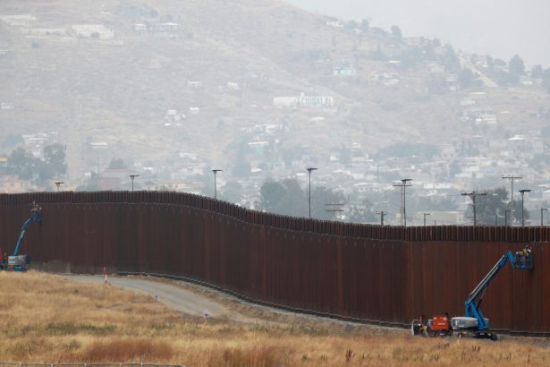 Workers weld sections of a newly replaced border wall near Tijuana, Mexico at the Otay Mesa border crossing in San Diego, Calif., on May 31, 2019. (Mike Blake/Reuters)