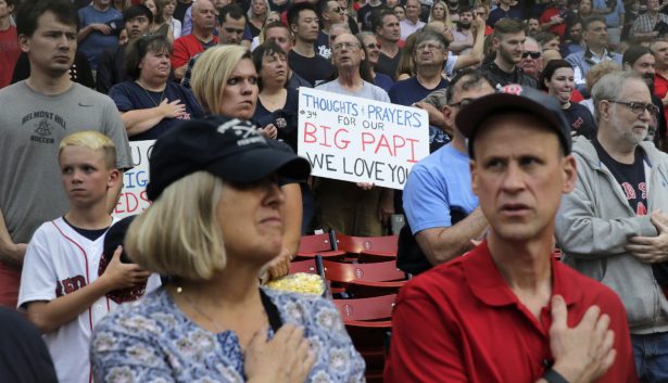 A fan holds a sign sending thought and prayers to former Boston Red Sox designated hitter David Ortiz, who was shot Sunday evening in the Dominican Republic, prior to a baseball game against the Texas Rangers at Fenway Park in Boston on June 10, 2019. (AP Photo/Charles Krupa)