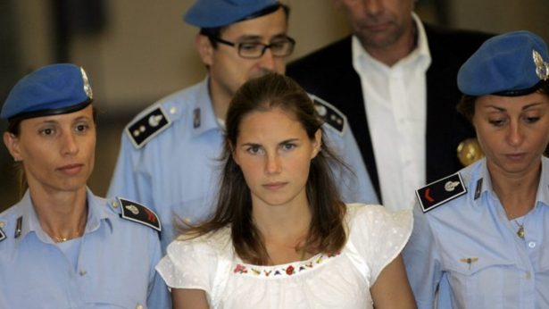 Amanda Knox, center, is escorted by Italian penitentiary police officers from Perugia's court after a hearing, central Italy, on Sept. 16, 2008. (Antonio Calanni/AP Photo)