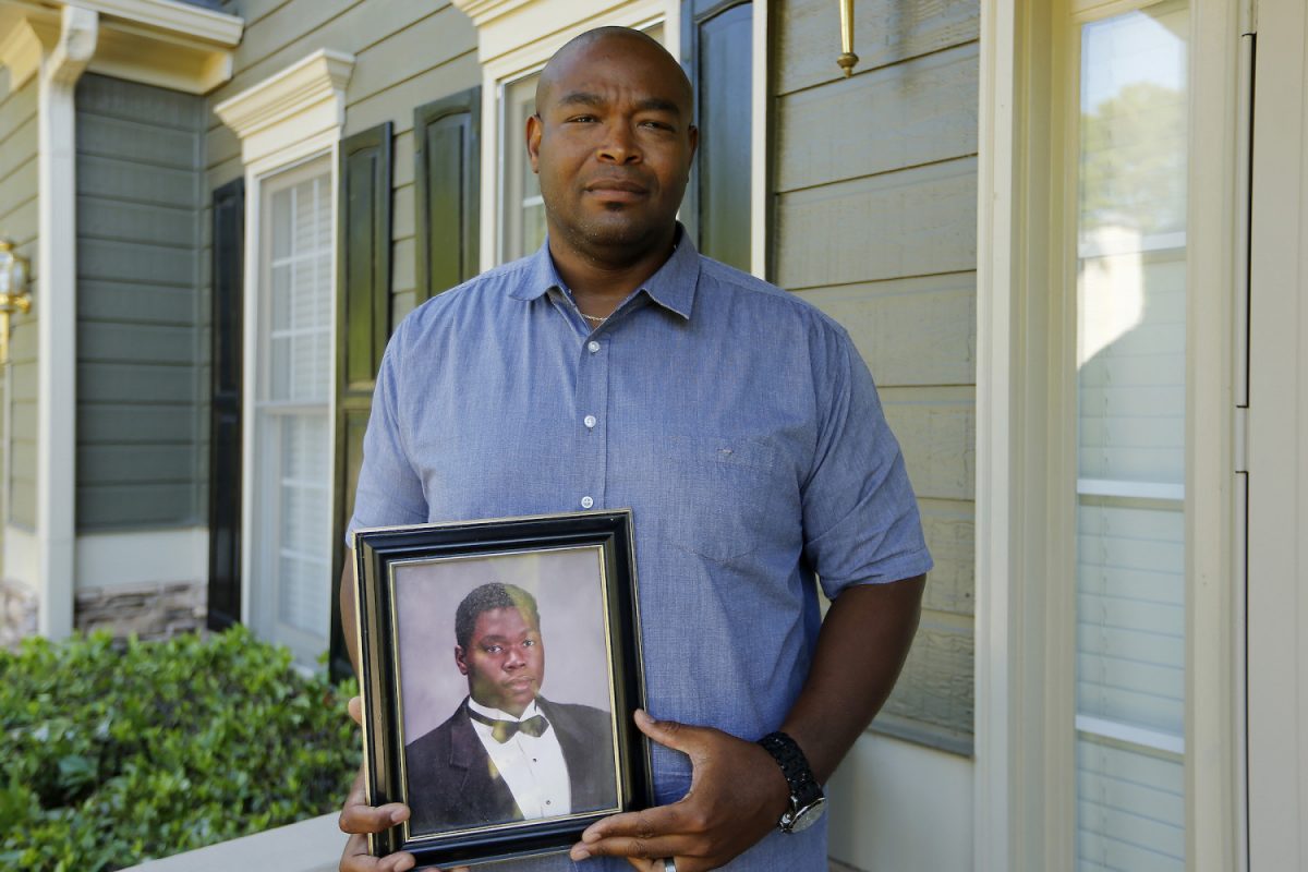 Chris Parks poses with a portrait of his brother Donovan Corey Parks in Powder Springs, Ga. on June 14, 2019. (AP Photo/Andrea Smith)