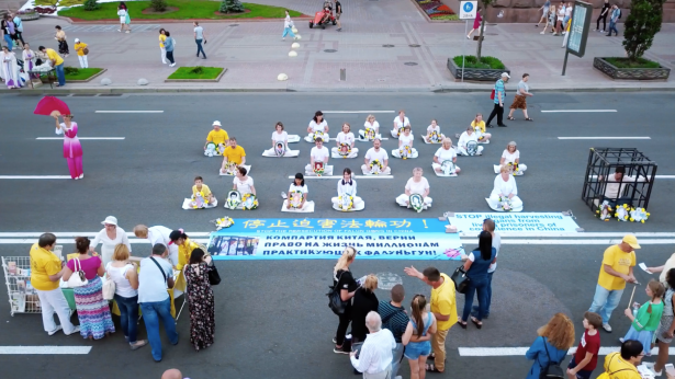 Practitioners of Falun Dafa meditate while holding photos of those who have died as a result of the persecution of Falun Dafa, in Kyiv, Ukraine, on June 1, 2019. (NTDTV)