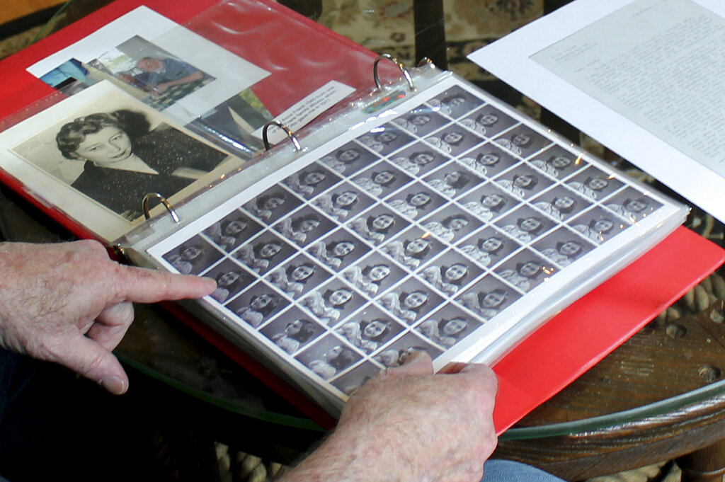 In this June 7, 2019 photo, Ryan Cooper shows photos of Anne Frank that he kept in a scrapbook at his home in Yarmouth, Mass. The 48 small images were made in a photo booth in 1940. Cooper has donated a trove of letters and mementos he received from her father, Otto Frank, to the U.S. Holocaust Memorial Museum ahead of the 90th anniversary of Anne Frank's birthday. (Philip Marcelo/AP Photo)