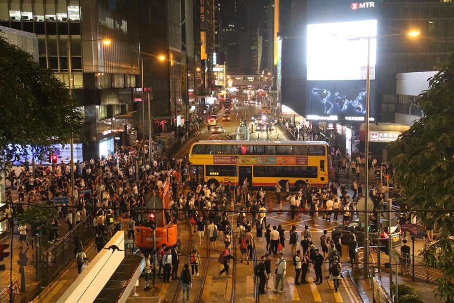 Protesters retreated to the street near the Far East Finance Centre in Hong Kong after police fired off tear gas and pepper spray to disperse the crowd. (Dennis Law/The Epoch Times)
