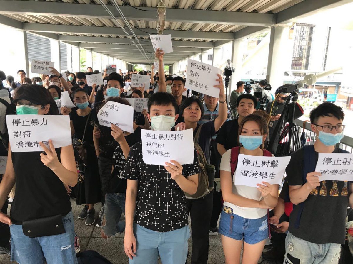 Protesters hold up signs that read “Stop Violence Against Hong Citizens” and “Stop Shooting At Hong Kong Students” at the Citic Bridge in Hong Kong on June 13, 2019. (Cai Wenwen/The Epoch Times)