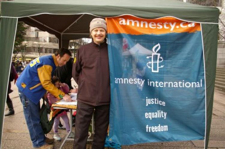 A man signs a petition at an Amnesty International booth in Vancouver during a Human Rights Day rally, Sept. 28, 2015. (Sherry Dong/The Epoch Times)