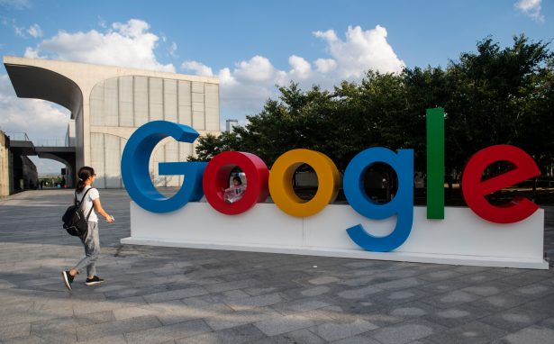 A woman and her child play on a Google sign at the World Artificial Intelligence Conference (WAIC) in Shanghai on Sept. 26, 2018. (Johannes Eisele/AFP/Getty Images)