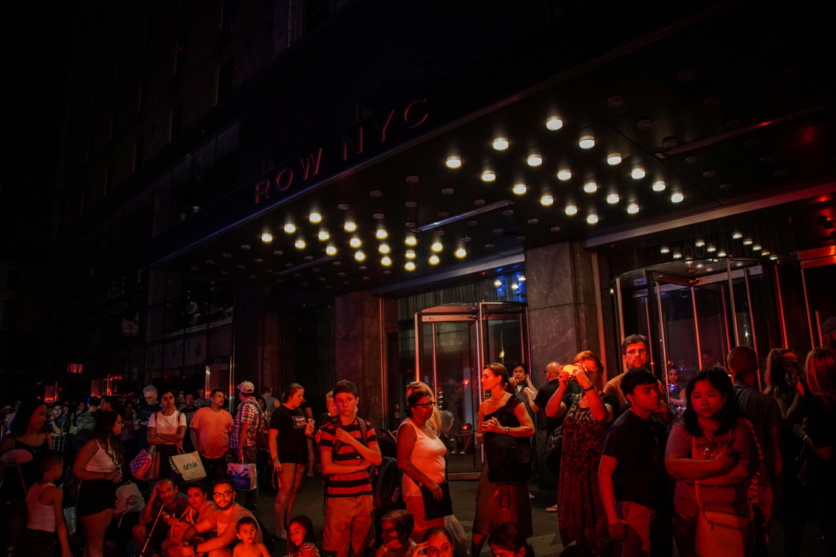 People are evacuated outside Row NYC hotel, as a blackout affects buildings and traffic during widespread power outages in the Manhattan borough of New York, U.S, July 13, 2019. (Jeenah Moon/Reuters)
