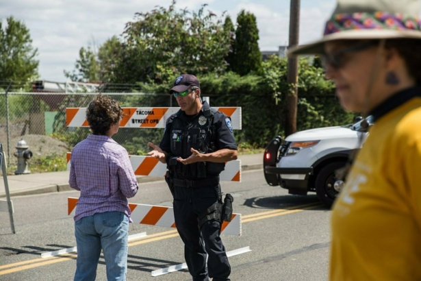 Police Officer Sam Lopez turns away would-be protesters in front of a roadblock near the Northwest Detention Center in Tacoma, Wash., on July 13, 2019. (Rebekah Welch/The Seattle Times via AP)