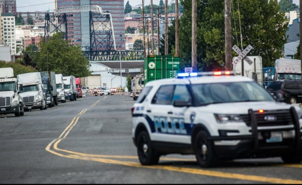 A police officer guards the front of a road block near the Northwest Detention Center in Tacoma, Wash. on July 13, 2019. (Rebekah Welch/The Seattle Times via AP)