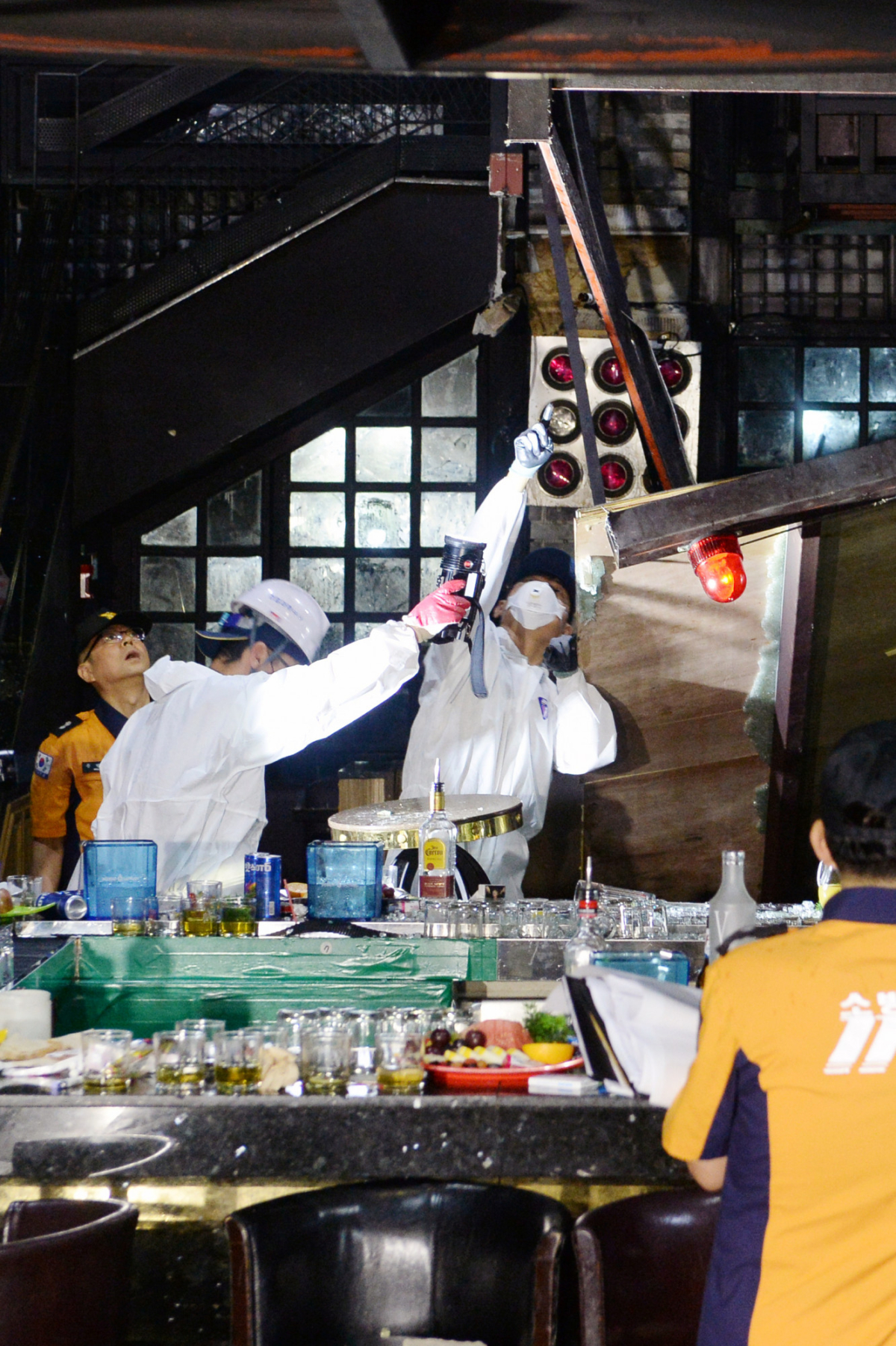 South Korean firefighters and officials examine the collapsed structure of a nightclub where several athletes competing at the World Aquatics Championships were dancing, in Gwangju, South Korea, July 27, 2019. (Yonhap via Reuters)
