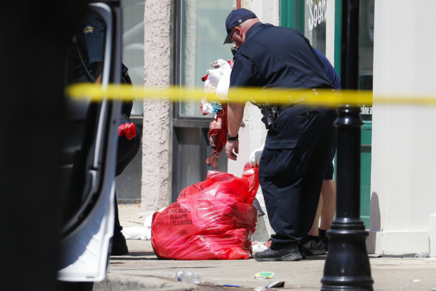 Authorities remove bloody rags and debris at the scene of the mass shooting in Dayton, Ohio, on Aug. 4, 2019. (John Minchillo/AP Photo)