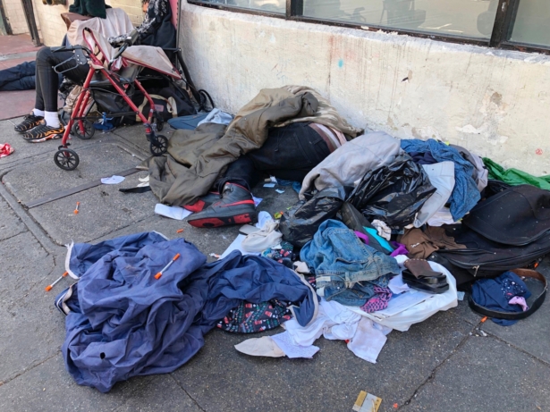 Sleeping people, discarded clothes and used needles are seen on a street in the Tenderloin neighborhood in San Francisco on July 25, 2019. (Janie Har/AP Photo)