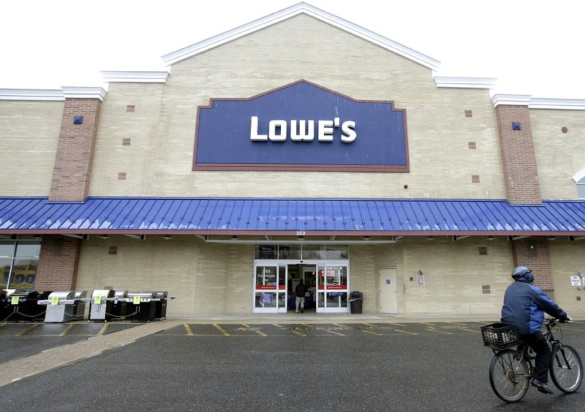 A cyclist rides near an entrance to a Lowe's retail home improvement and appliance store in Framingham, Mass., on Feb. 23, 2018. (Steven Senne/File Photo/AP)