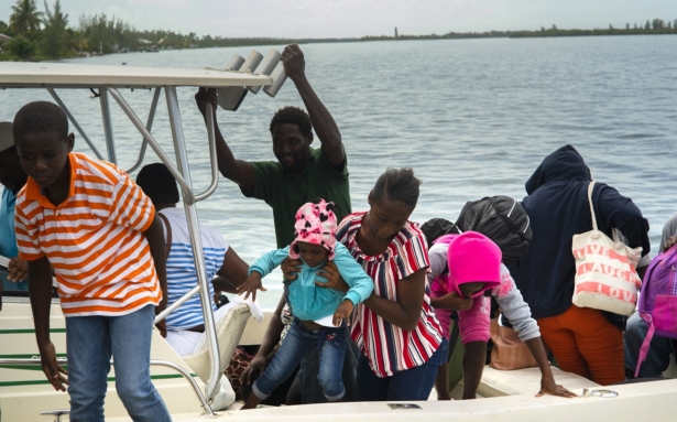 A woman carries a girl in her arms after being evacuated from a nearby Cay due to the danger of floods after arrive on a ship at the port before the arrival of Hurricane Dorian in Sweeting's Cay, Grand Bahama, Bahamas, on Aug. 31, 2019. (Ramon Espinosa/AP Photo)