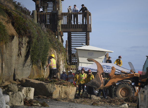 Search and rescue personnel work at the site of a cliff collapse at a popular beach in Encinitas, California, on Aug. 2, 2019. (AP Photo/Denis Poroy)