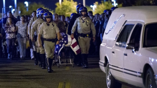 The casket of slain CHP officer Andre Moye is transported to a hearse from the Riverside University Health Systems Medical Center after he was shot and killed while two fellow officers were wounded during a traffic stop on Eastridge Avenue overpass over the 215 Freeway in Riverside in Moreno Valley, Calif., on Aug 12, 2019. (Terry Pierson/The Orange County Register via AP)