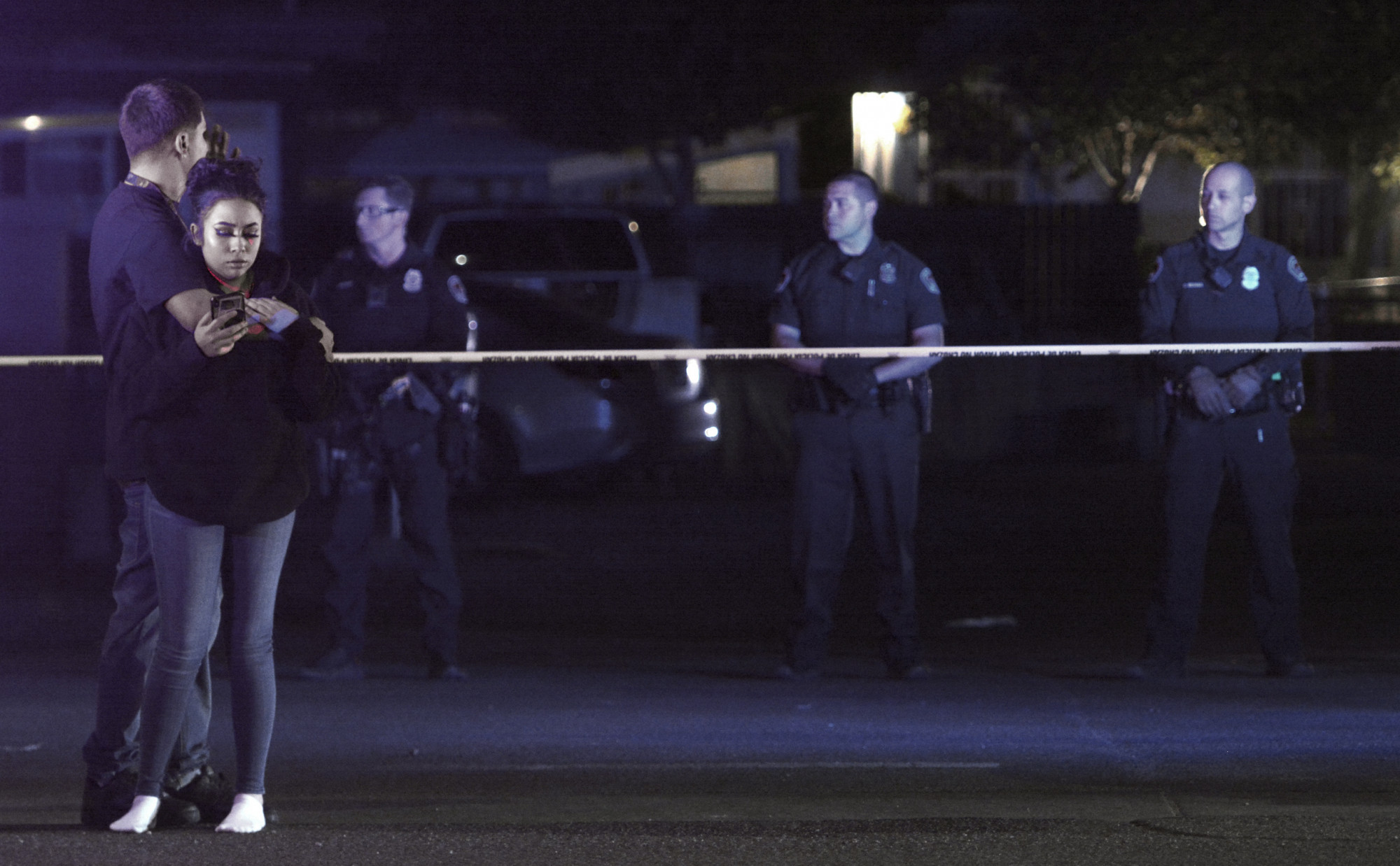 Two people stand in front of the police tape at the scene of a shooting on Thursday, Sept. 12, 2019 in Albuquerque, N.M. (Greg Sorber/The Albuquerque Journal via AP)