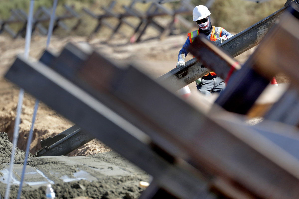 A government contractor, surrounded by existing Normandy barriers that separate Mexico and the United States, pours a concrete footer in preparation for a section of Pentagon-funded border wall along the Colorado River on Sept. 10, 2019 in Yuma, Ariz. (Matt York/AP Photo)