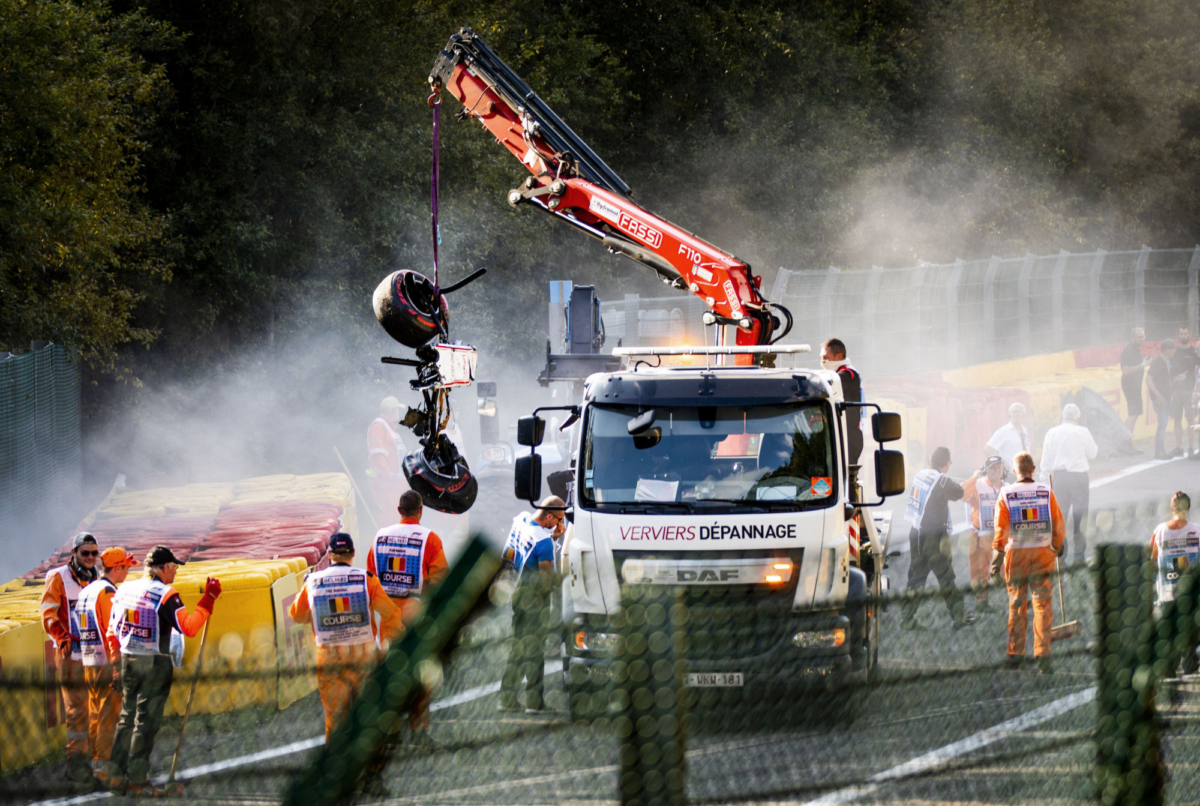Track marshals look on as a crane lift parts of the damaged car of Sauber's Ecuadorian driver Juan Manuel Correa onto a truck following a serious accident involving several drivers during a Formula 2 race at the Spa-Francorchamps circuit in Spa, Belgium, on Aug. 31, 2019. (REMKO DE WAAL/AFP/Getty Images)
