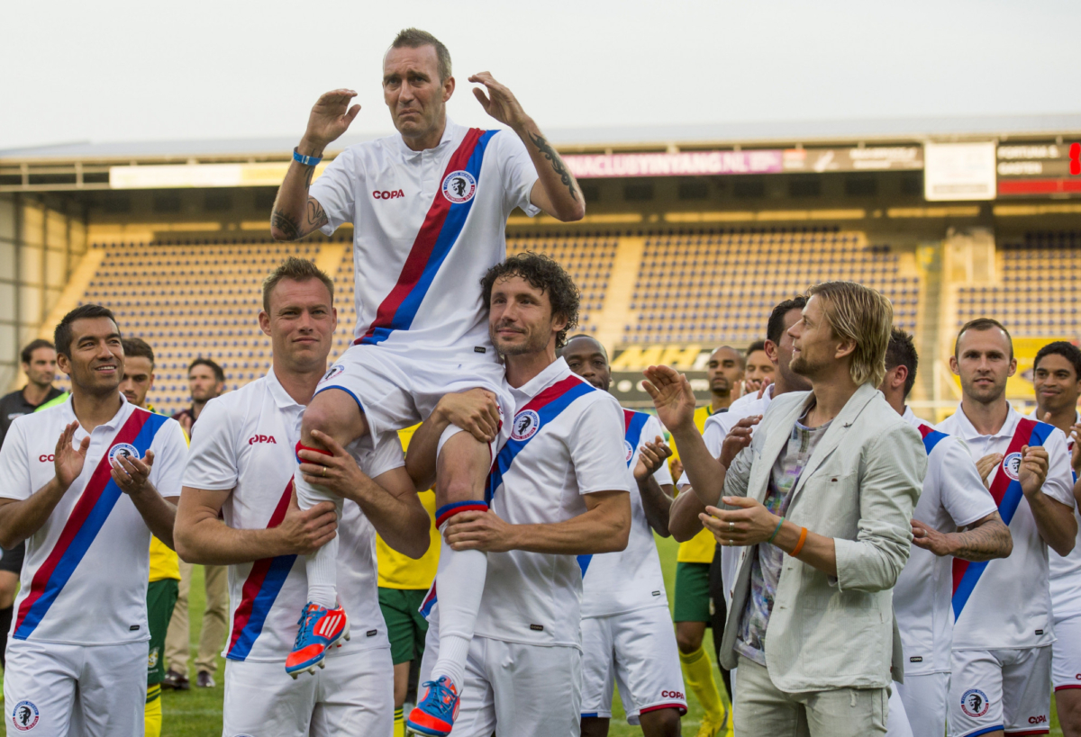 Former Dutch soccer player Fernando Ricksen (Top), seated on the shoulders of former soccer players Kevin Hofland (L) and Mark van Bommel (R) reacts following a charity football match in his childhood town of Sittard on May 25, 2014. (Marco De Swart/AFP/Getty Images)