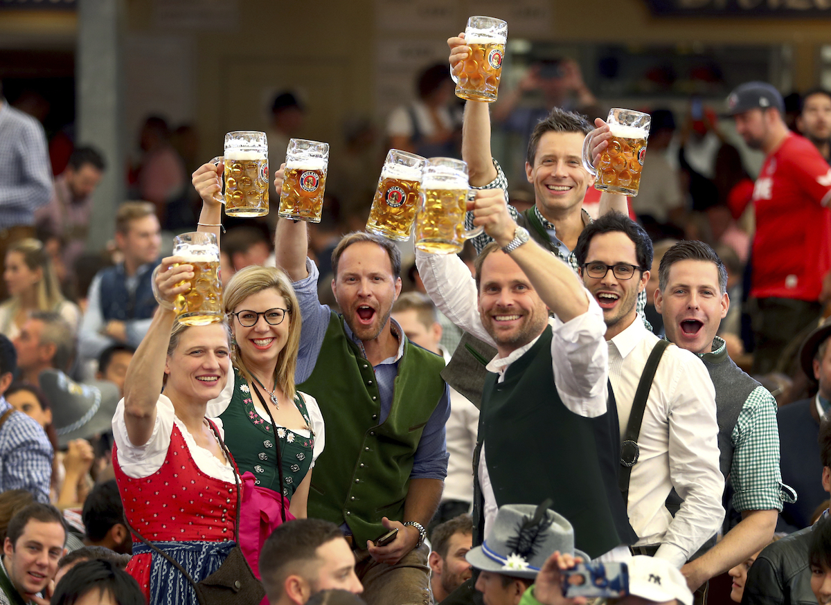 Visitors lift glasses of beer during the opening of the 186th 'Oktoberfest' beer festival in Munich, Germany, on Sept. 21, 2019. (AP Photo/Matthias Schrader)